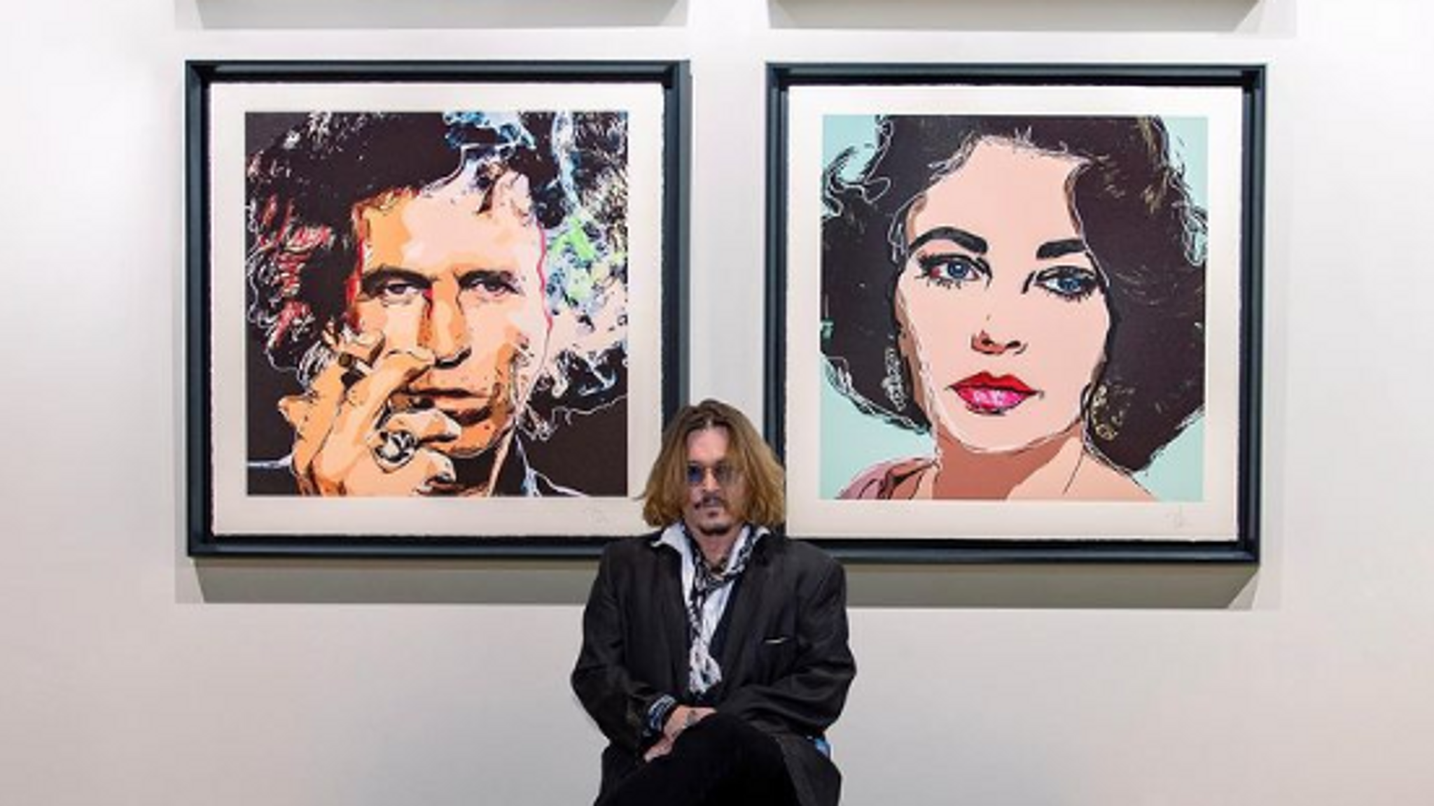 Johnny Depp in front of his two paintings